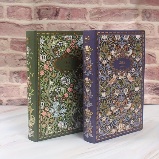 Two ornately decorated books with floral patterns on a brick wall background