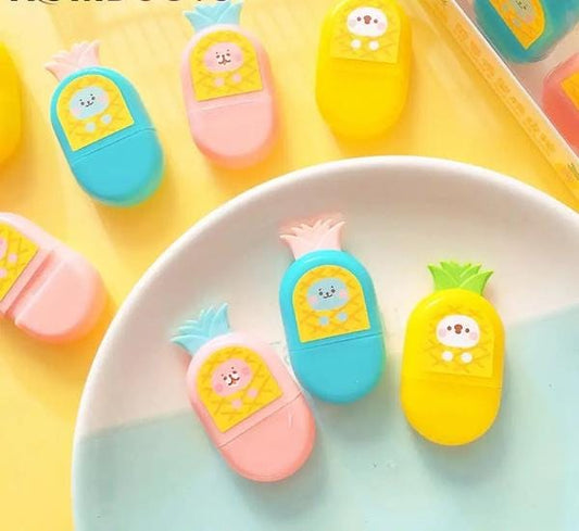 Colorful pineapple-shaped erasers on a yellow background