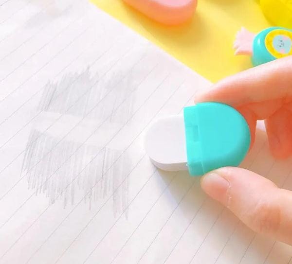 Hand holding a turquoise eraser over a piece of paper