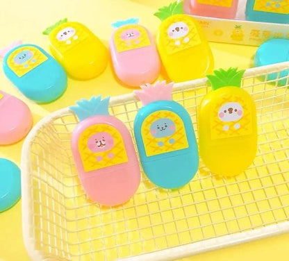 Colorful pineapple-shaped containers with cartoon faces on a yellow background