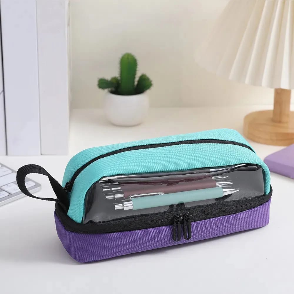 Two-tone purple and teal pencil case with clear compartment on a desk.