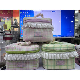 Set of green and white fabric storage boxes with lids on a table.