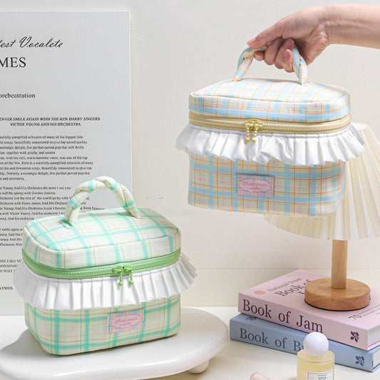 Two plaid-patterned vanity cases with handles on a white surface.