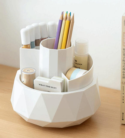 White geometric desk organizer with stationery items on a wooden surface.