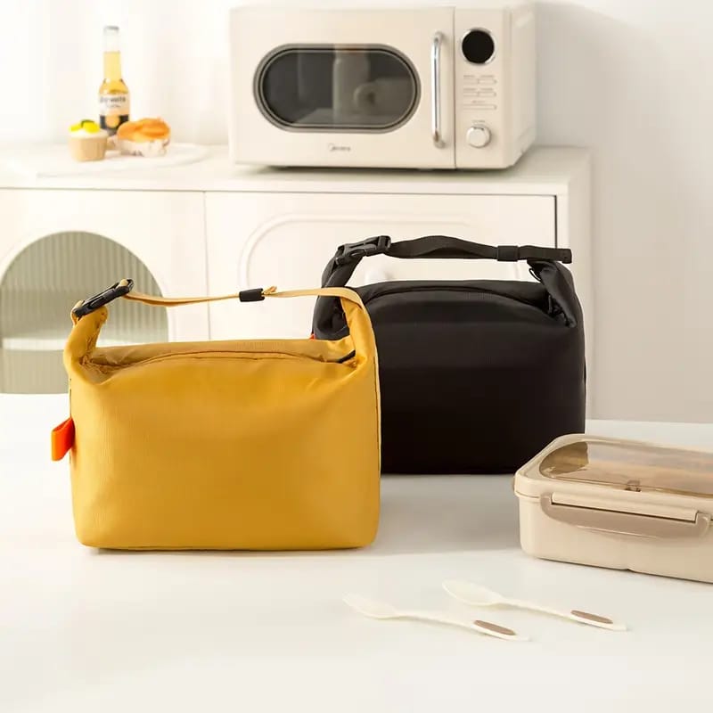 Yellow and black bags on a kitchen counter with a microwave in the background
