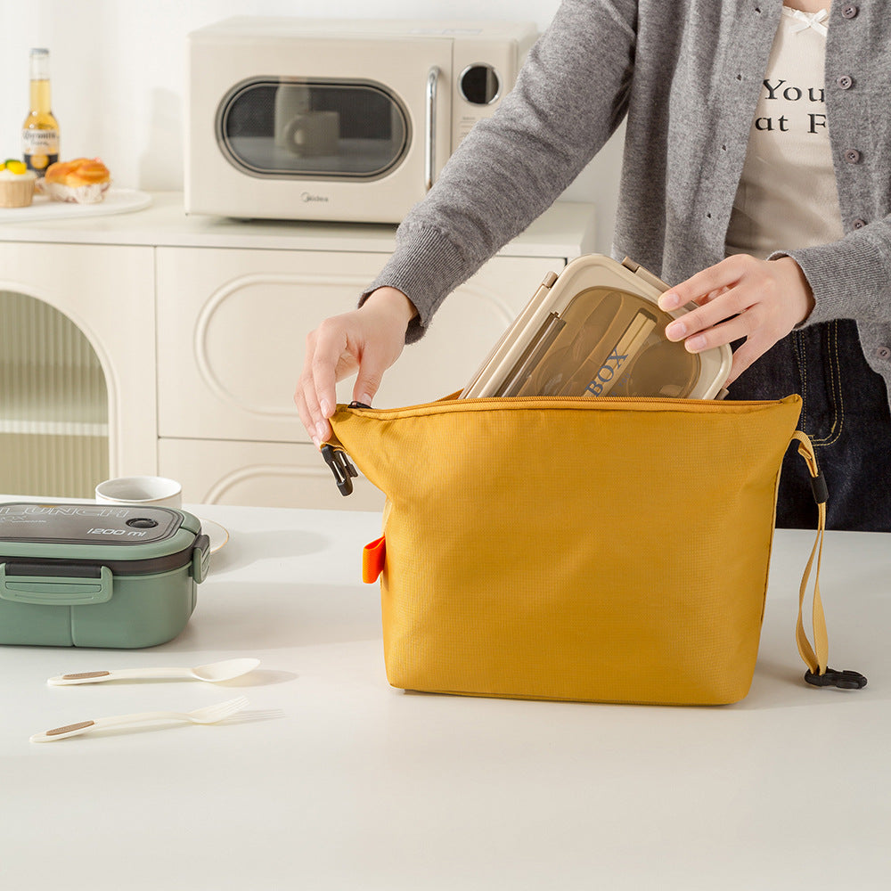 Person opening a yellow bag with kitchen items on a counter